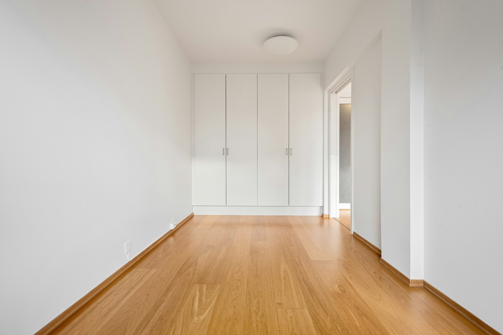 Besenrein geräumtes, helles Zimmer mit Holzboden